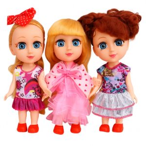 Three dolls with big blue eyes, wearing colorful dresses and red shoes, standing side by side