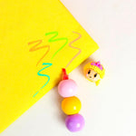 Colorful ball pen with a character top on a yellow background