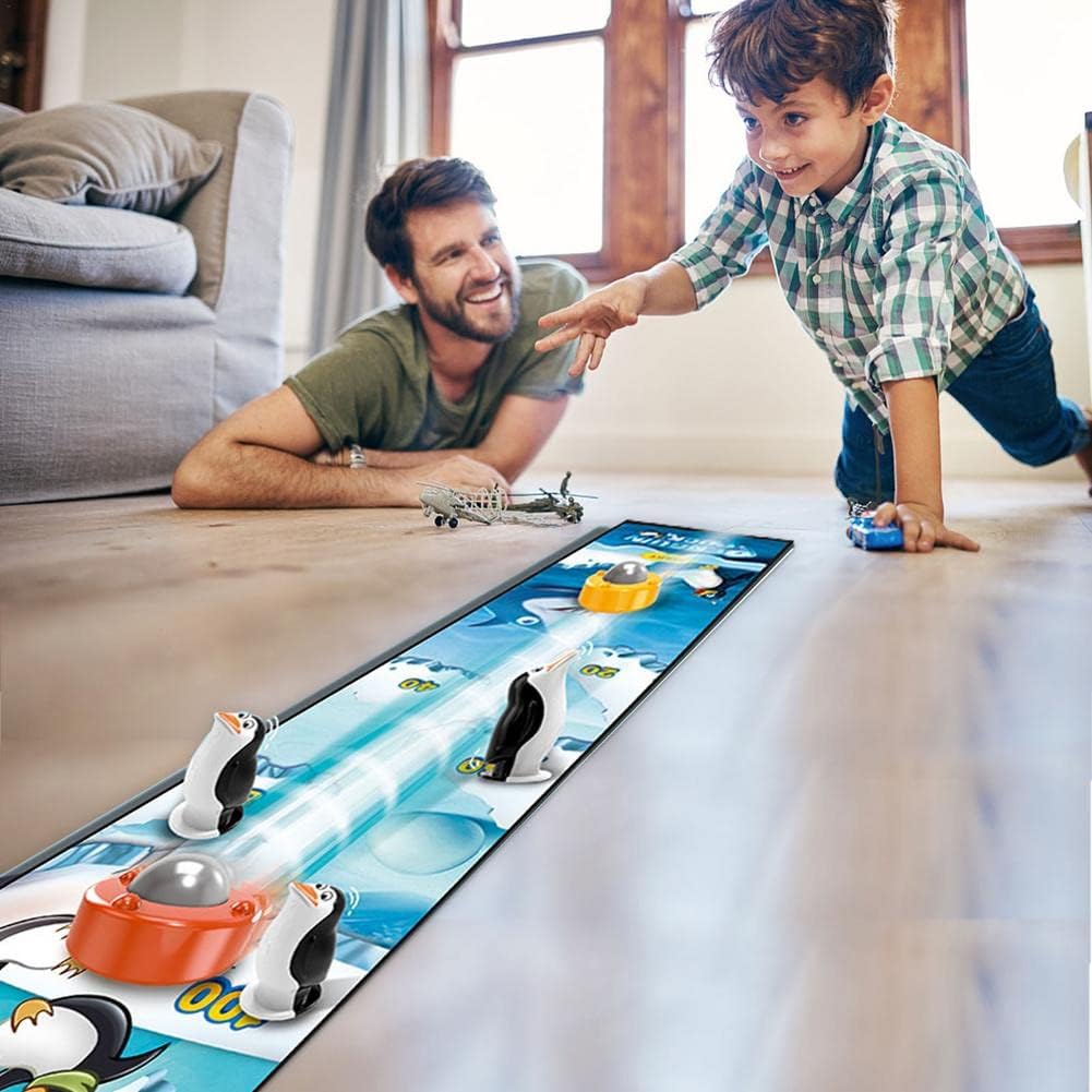 Child and adult playing with a toy penguin setup on a table