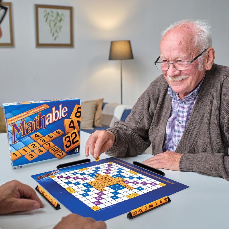 Man playing a board game with a 'Mathable' box on a table.