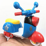 Colorful toy scooter held in a hand against a white background
