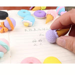 Colorful ice cream-shaped erasers on a notebook page.