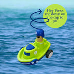 Toy boat with a blue cap on water, labeled 'Press me down on the cap to go'.