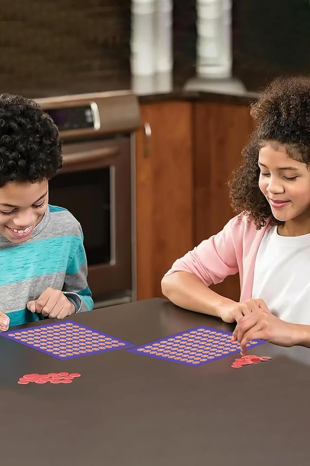 Two children playing with pattern blocks at a kitchen table.