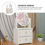 White cosmetic mirror with drawers on a wooden floor, surrounded by decorative items.