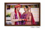Framed photograph of a couple in traditional wedding attire with a colorful background.