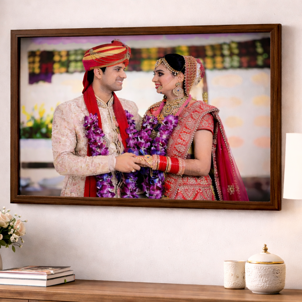 Framed photograph of a couple in traditional attire on a wall above a wooden console table with decorative items.