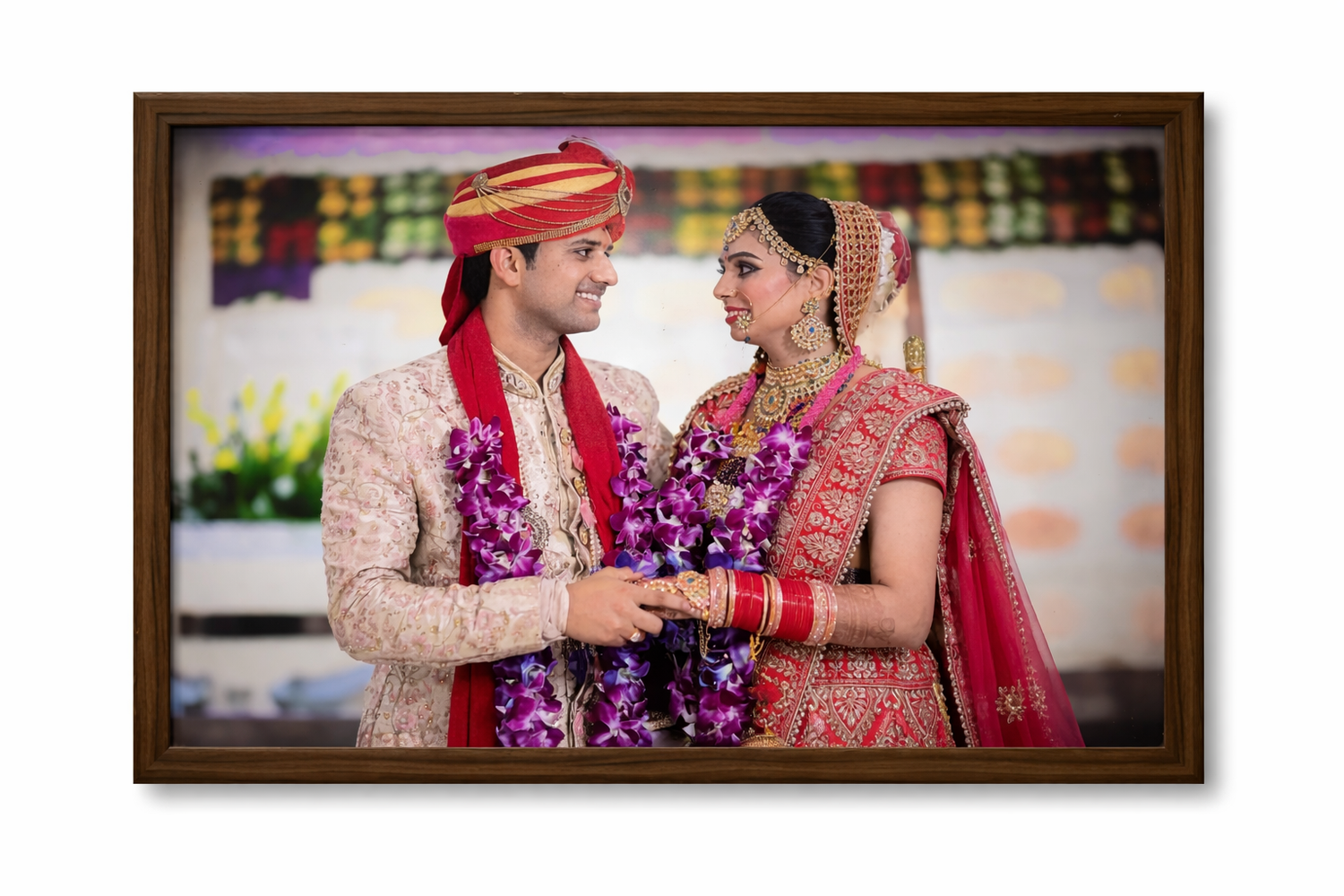 Framed photograph of a couple in traditional wedding attire with a colorful background.