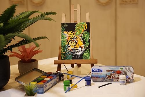 Art supplies including a painting of a tiger, paintbrushes, and a box of Dohs toys on a table.