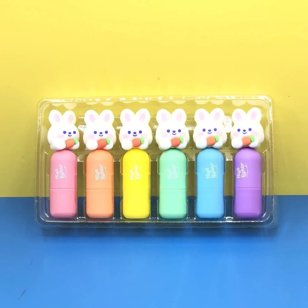 Set of six colorful rabbit-shaped highlighters in a clear plastic case on a yellow and blue background.