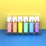 Set of six colorful rabbit-shaped highlighters in a clear plastic case on a yellow and blue background.
