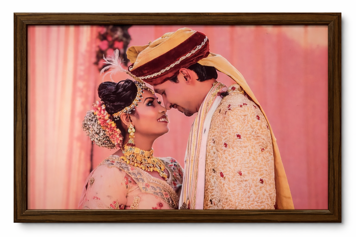 Couple in traditional wedding attire against a pink background