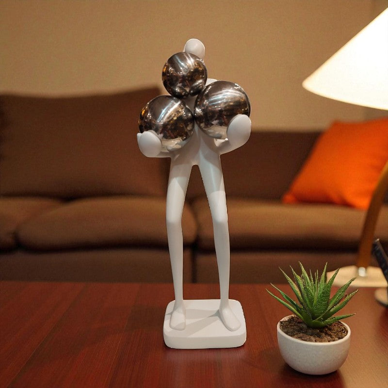 Decorative sculpture on a table with a lamp and couch in the background