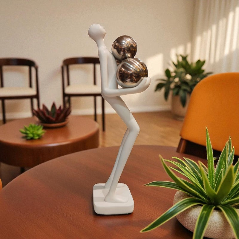 Abstract sculpture on a table with indoor plants and chairs in the background