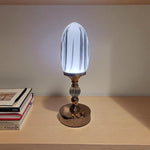 Decorative table lamp with a glass shade on a wooden surface