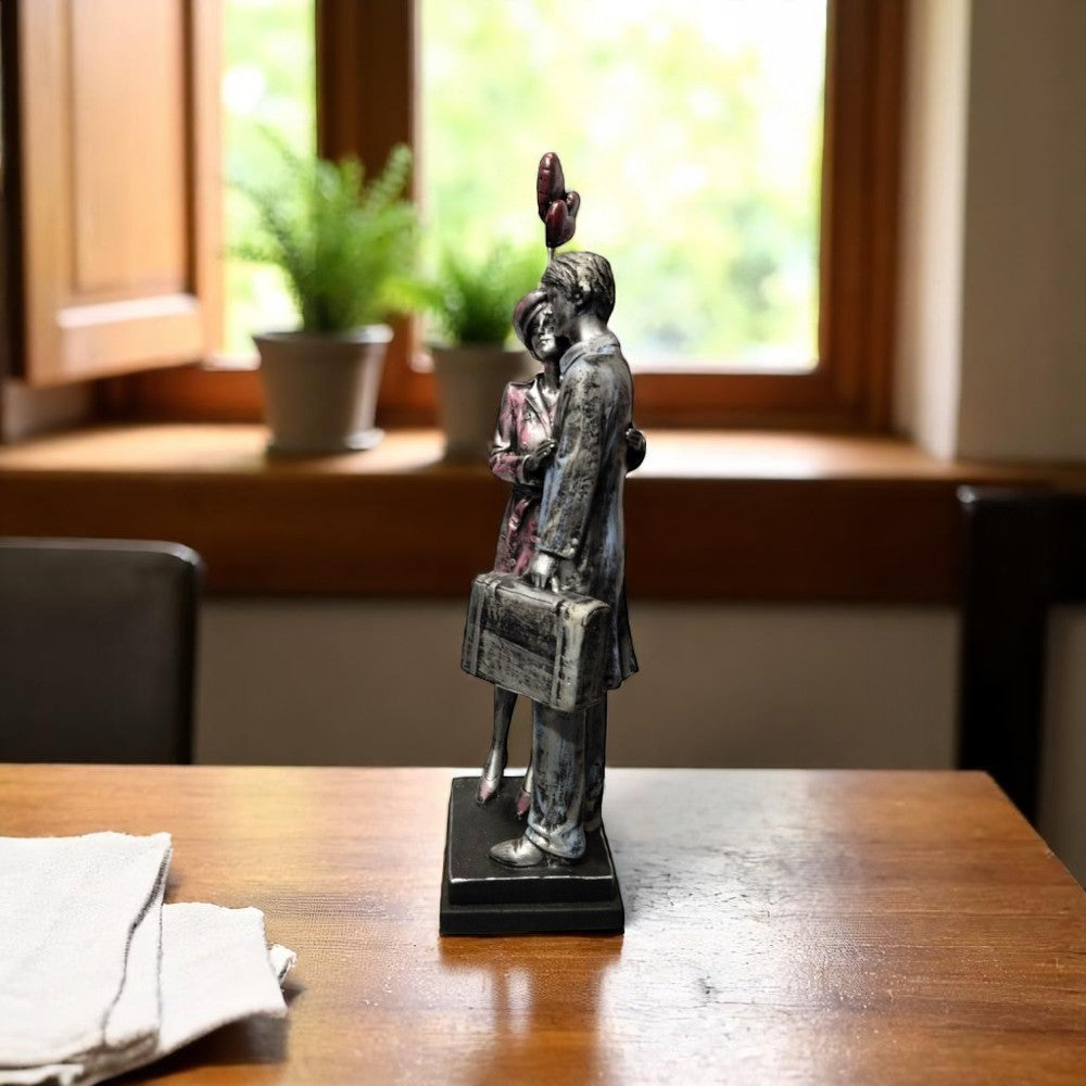 Side view of emotional couple showpiece holding heart balloons - Motumal Giftwala