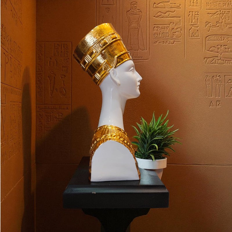 Bust with gold headpiece on a pedestal against an Egyptian hieroglyphs wall.