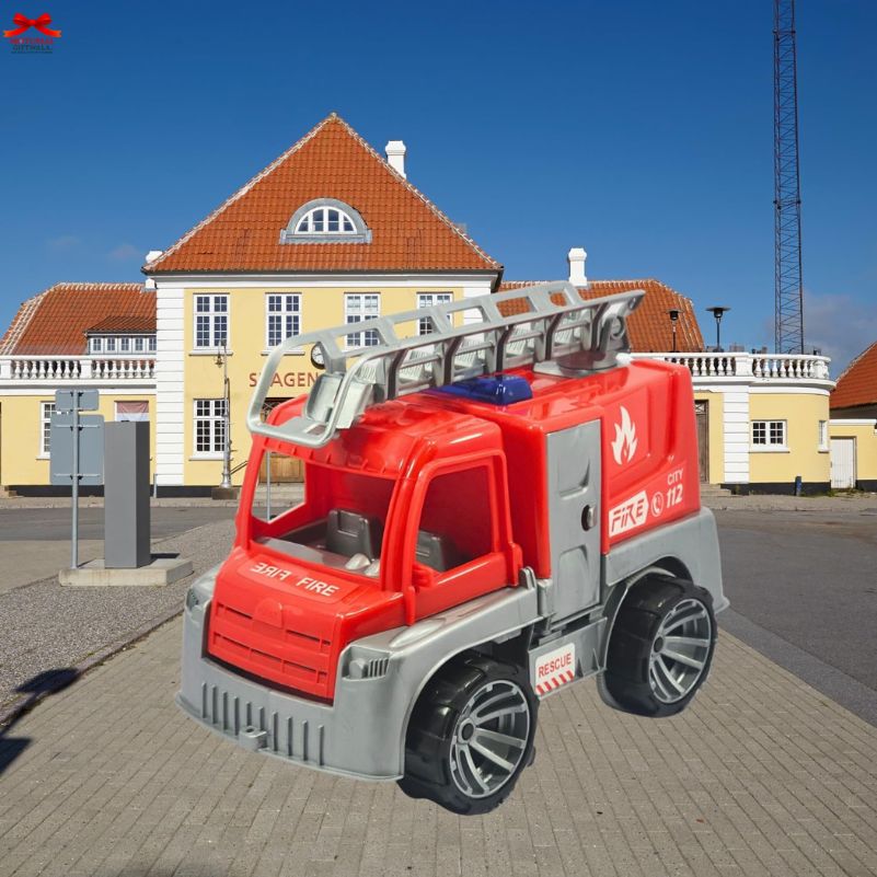Toy fire truck on a street with buildings in the background