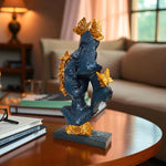 Decorative sculpture of a face with gold accents on a table in a living room.