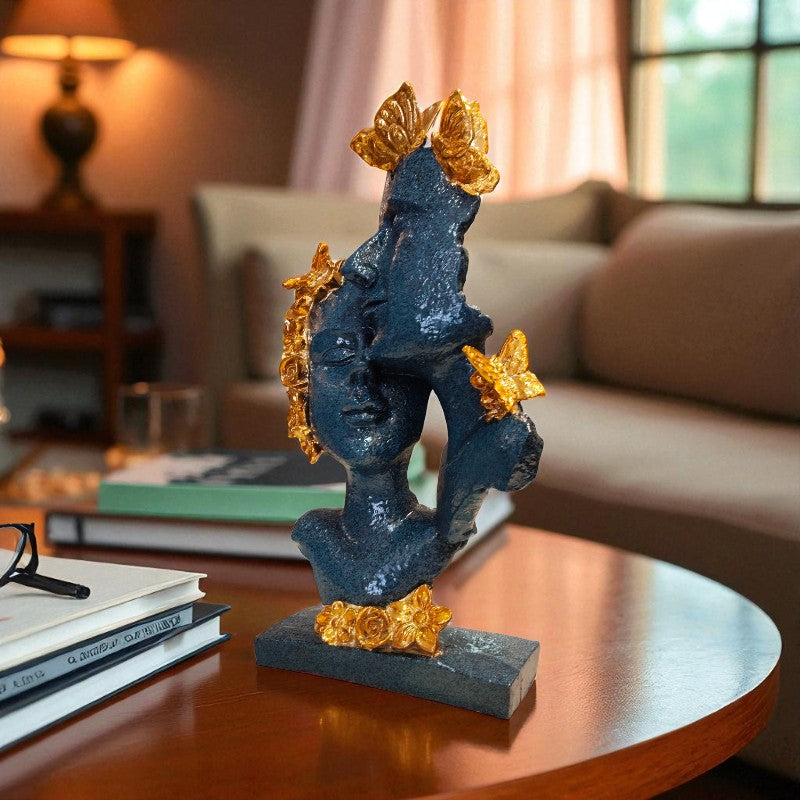 Decorative sculpture of a face with gold accents on a table in a living room.