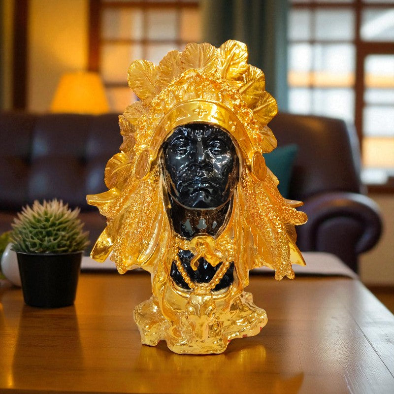 Decorative object with gold leaf design on a wooden surface in a room setting