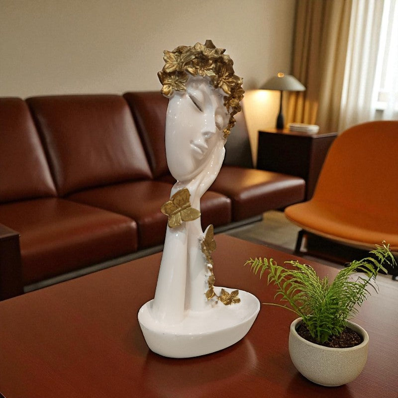 Decorative sculpture of a woman's head with flowers on a table in a living room.