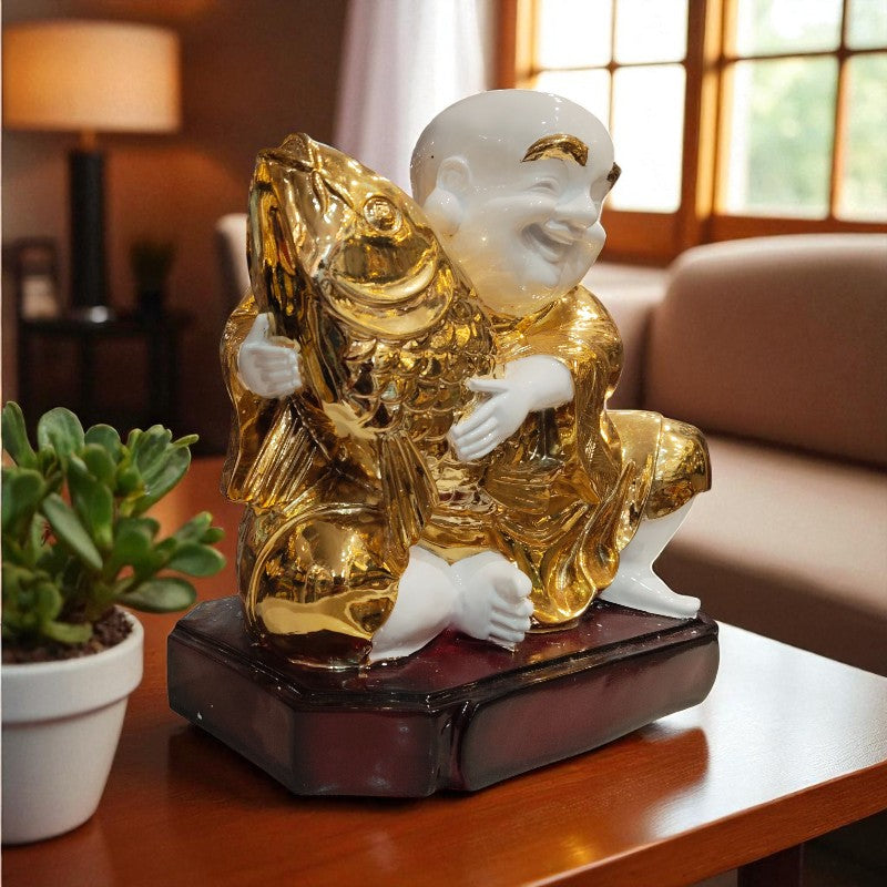 Decorative statue of a child holding a fish on a wooden table with a blurred background