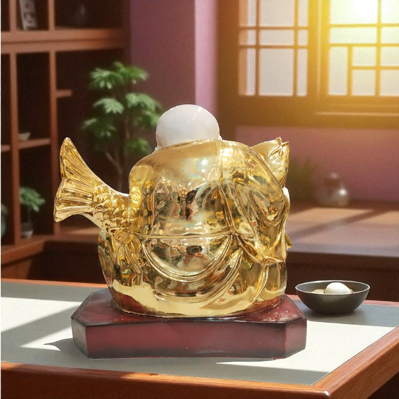 Gold fish-shaped incense burner on a wooden table with a soft focus background