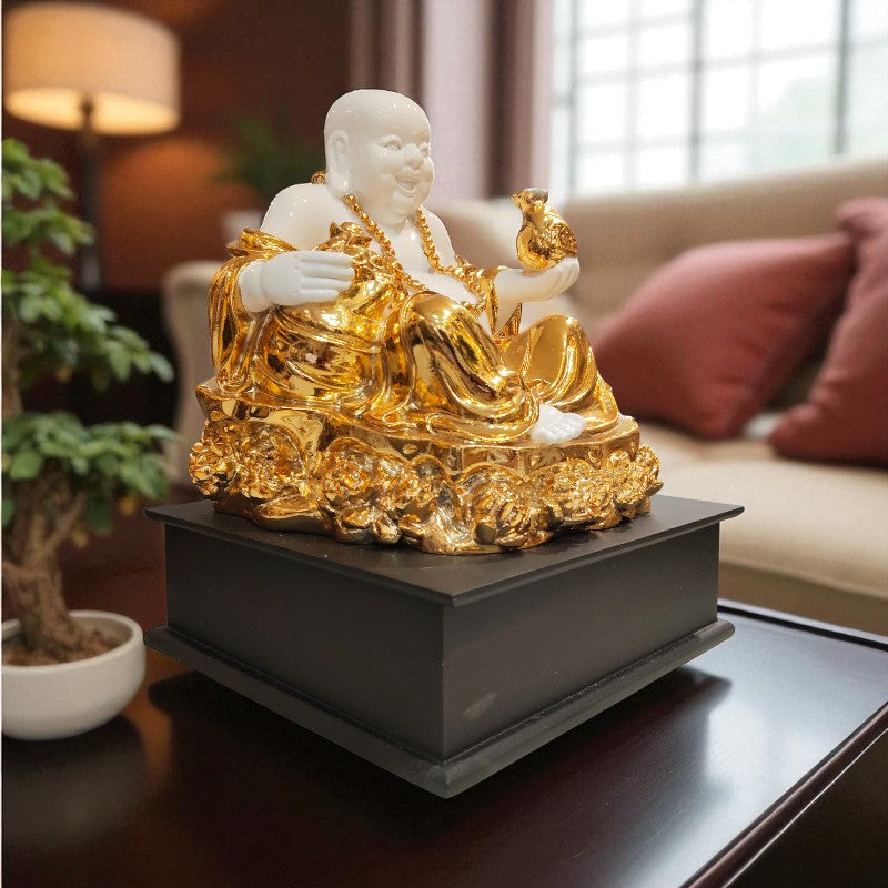 Gold and white Buddha statue on a dark surface with a blurred indoor background