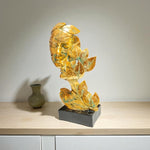 Decorative stone sculpture on a wooden surface with a plain background