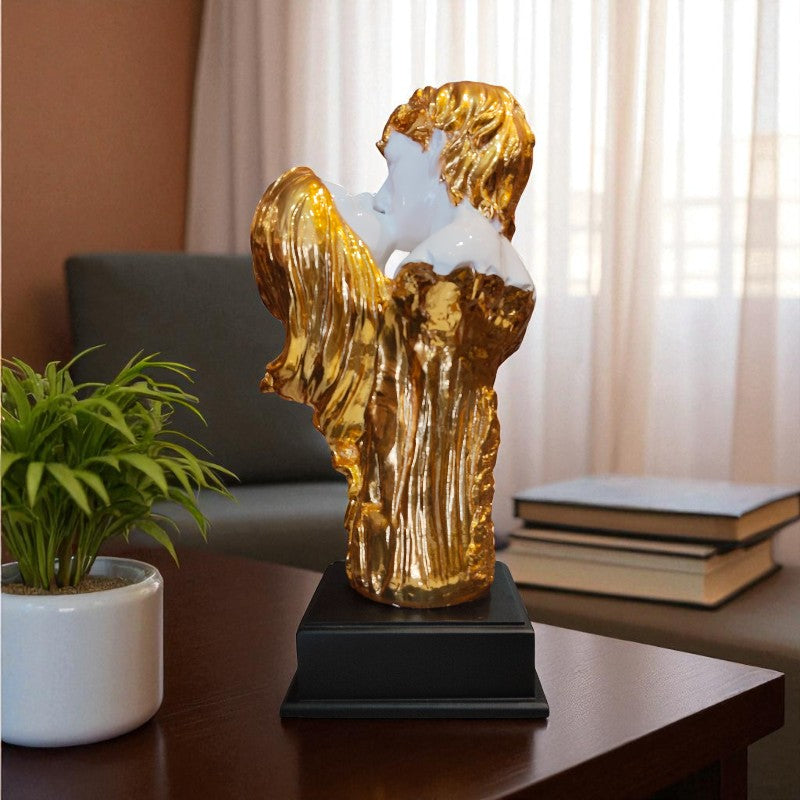 Gold angel sculpture on a table with books and a plant in the background