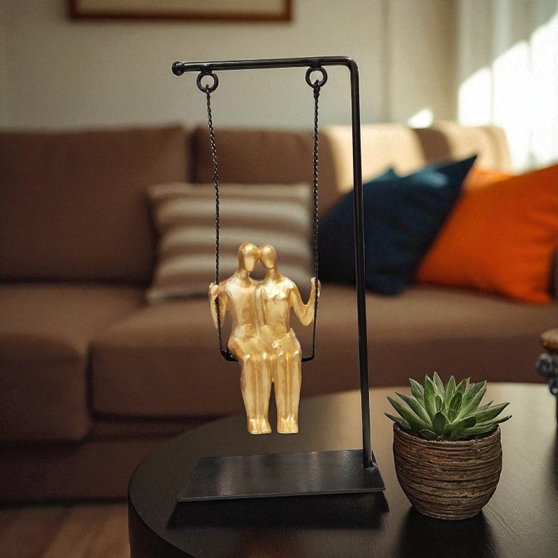 Decorative sculpture of two people on a swing on a stand in a living room setting.