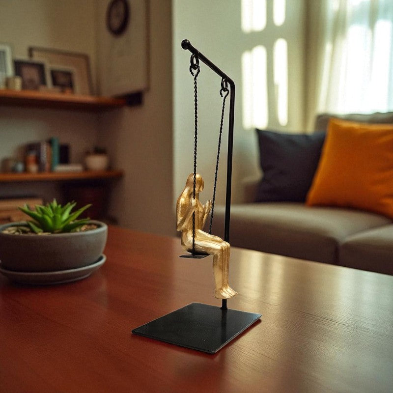 Decorative figure of a person on a swing on a stand in a living room setting.