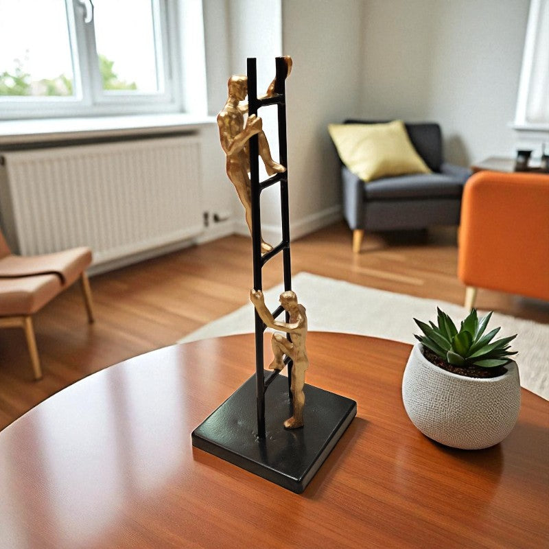 Decorative sculpture of three people on a ladder on a table in a living room.