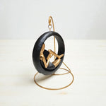 Decorative sculpture of a person in a black chair on a white background