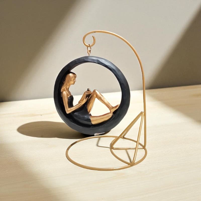 Decorative sculpture of a woman in a yoga pose on a wooden stand with a neutral background