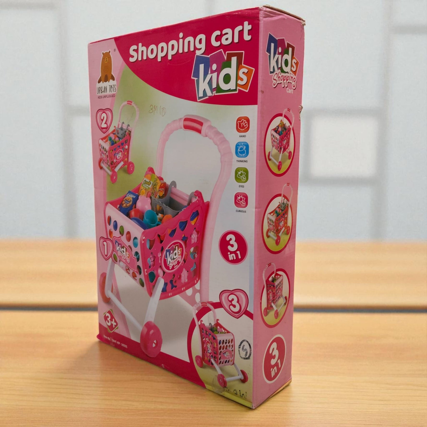 Side angle view of kids shopping cart toy set box showing cart features and contents
