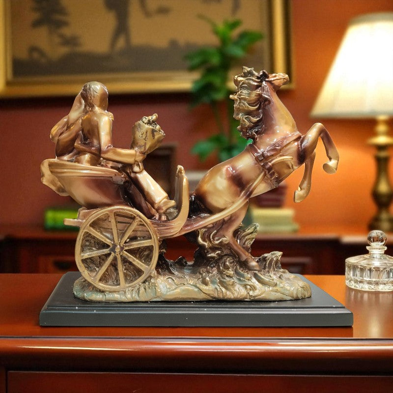 Bronze sculpture of a chariot with a horse and figures on a wooden surface.
