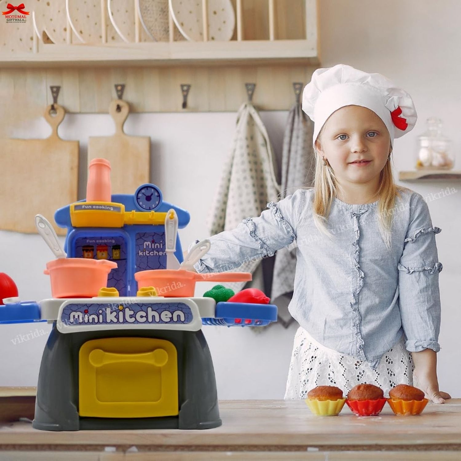 Child playing with a toy kitchen set in a kitchen setting