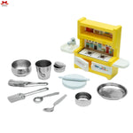 Toy kitchen set with yellow stove and silver utensils on a white background