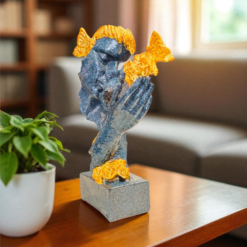 Decorative statue of a figure with gold accents on a table in a home setting