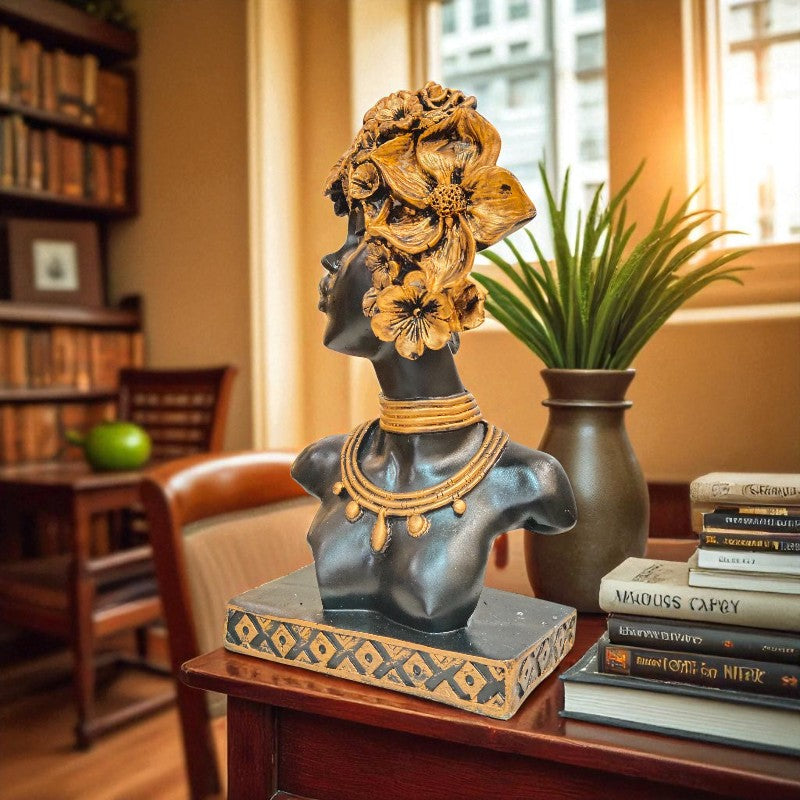 Decorative bust with floral headpiece on a table in a room with books and a plant.